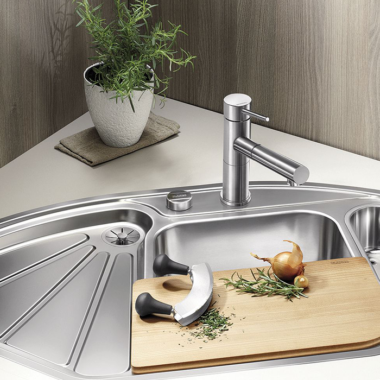 in the kitchen there is a stainless steel sink with 3 different compartments
