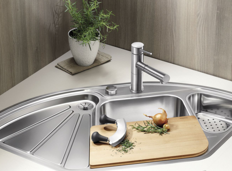 in the kitchen there is a stainless steel sink with 3 different compartments